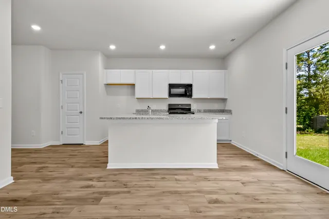 a white kitchen with wooden floor and a sink
