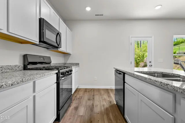 a kitchen with stainless steel appliances granite countertop a sink and a stove top oven