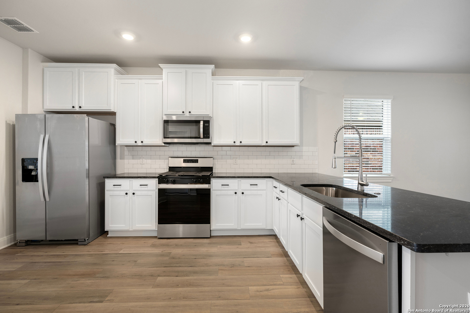 6306 Monk Landing Converse, TX 78109 - Photo 9 of 16 a kitchen with granite countertop a refrigerator stove and sink