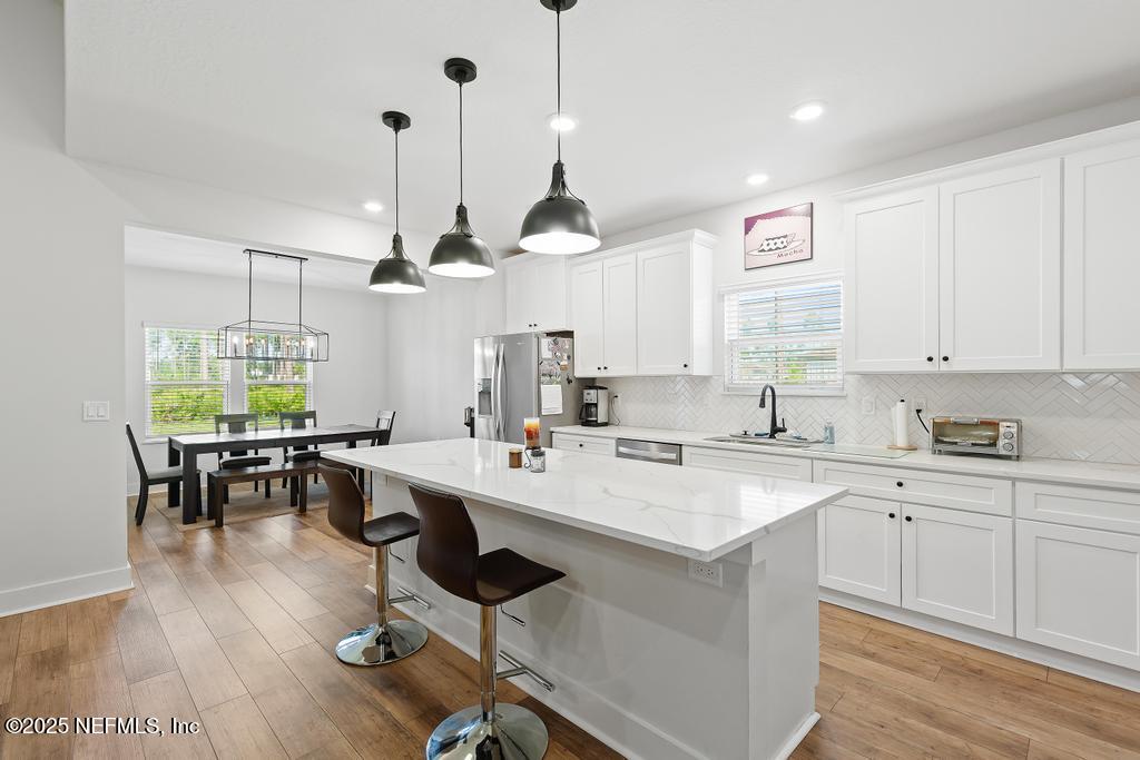 36012 Pitch Lane Hilliard, FL 32046 - Photo 13 of 54 a kitchen with a dining table chairs sink and cabinets