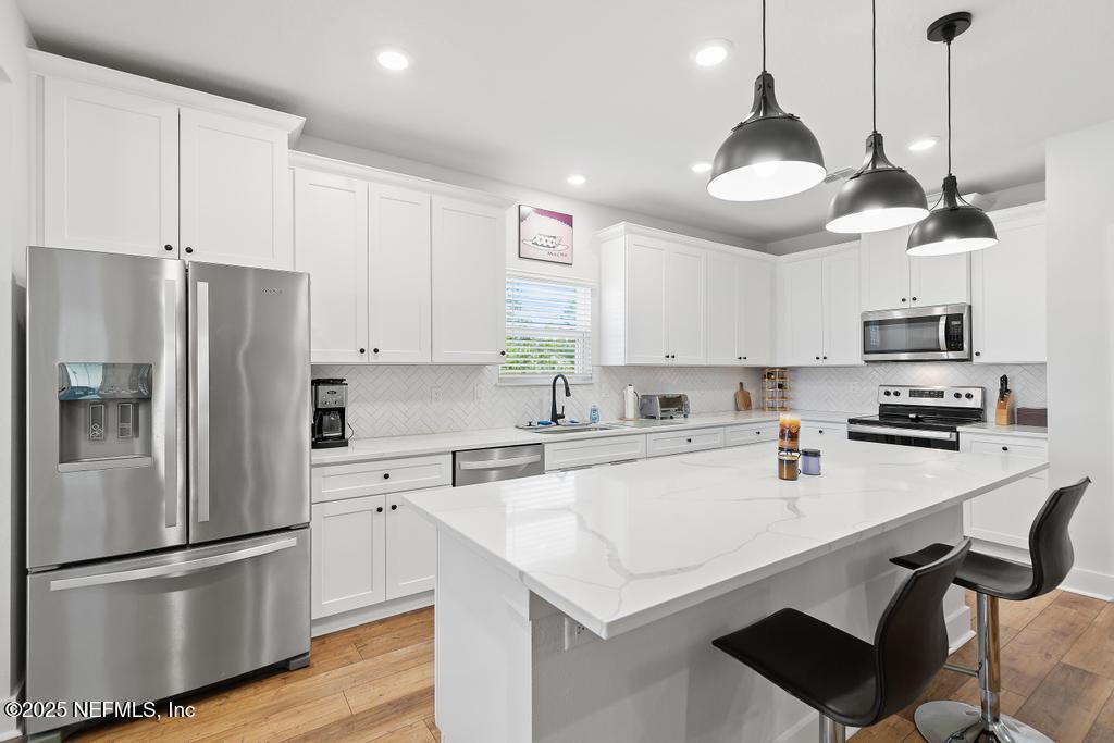 36012 Pitch Lane Hilliard, FL 32046 - Photo 15 of 54 a kitchen with stainless steel appliances a refrigerator a sink a stove a microwave and cabinets