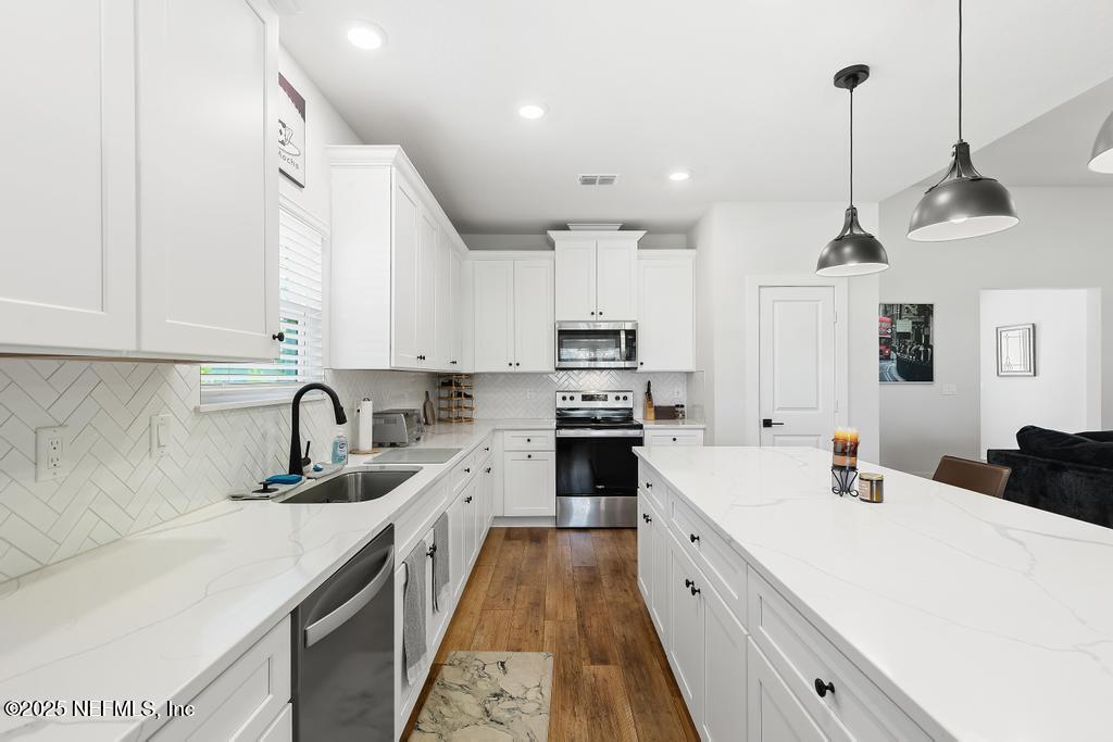 36012 Pitch Lane Hilliard, FL 32046 - Photo 16 of 54 a kitchen with white cabinets sink and white appliances