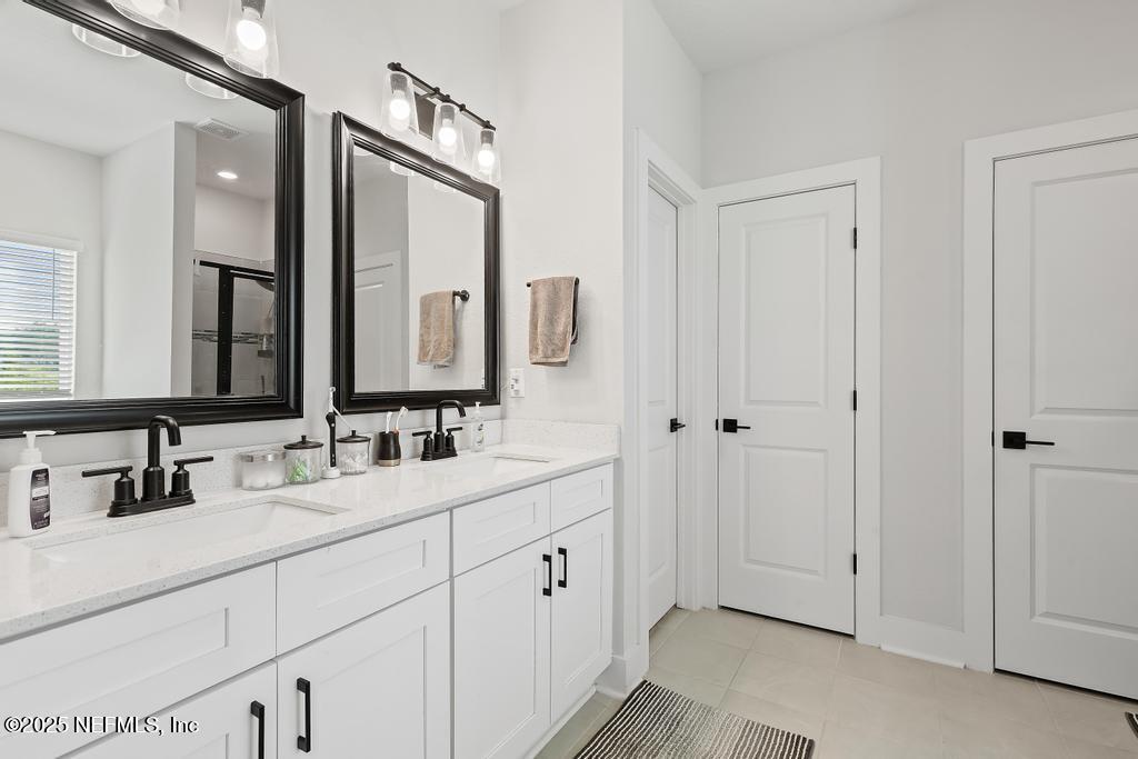 36012 Pitch Lane Hilliard, FL 32046 - Photo 36 of 54 a bathroom with a double vanity sink and mirror