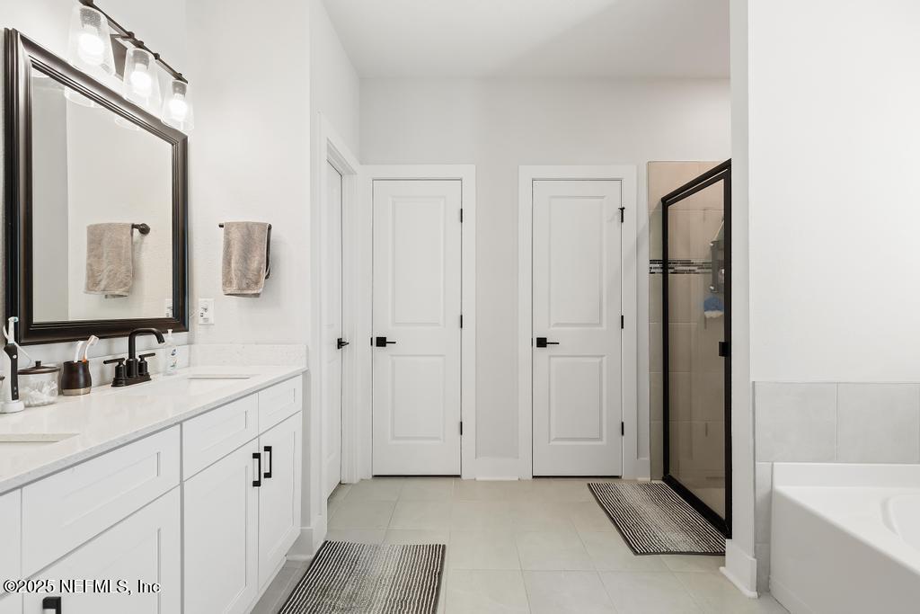 36012 Pitch Lane Hilliard, FL 32046 - Photo 37 of 54 a bathroom with a double vanity sink mirror and bathtub