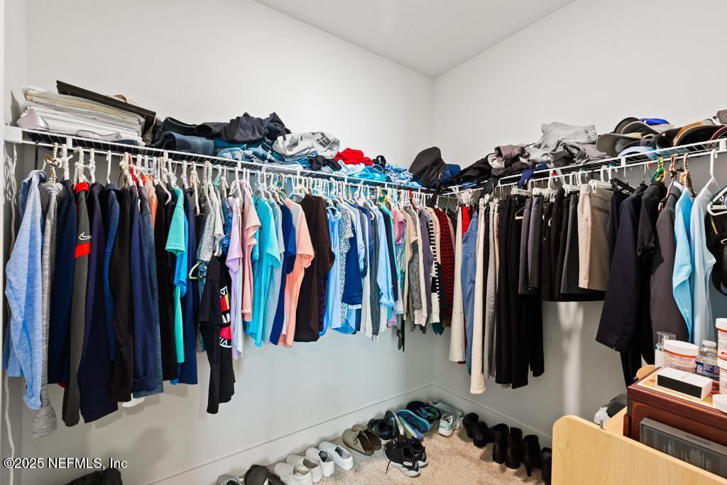 36012 Pitch Lane Hilliard, FL 32046 - Photo 40 of 54 a view of walk in closet with clothes