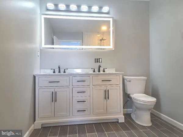 a bathroom with a sink a toilet and mirror