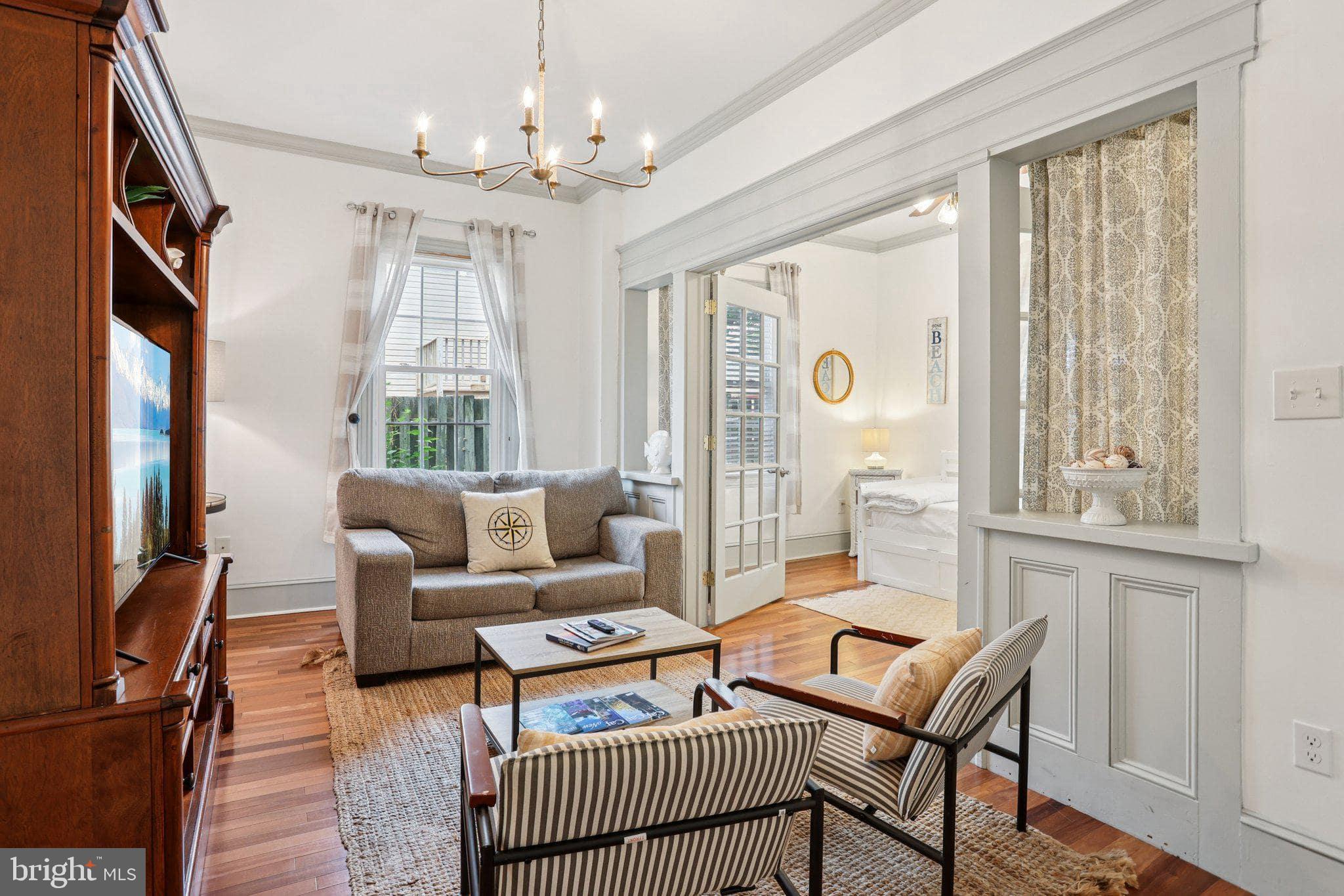 416 Broadway Cape May, NJ 08204 - Photo 27 of 49 a living room with furniture a chandelier and a window