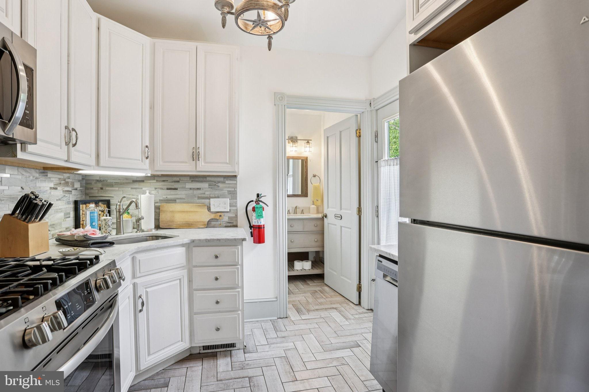 416 Broadway Cape May, NJ 08204 - Photo 36 of 49 a kitchen with stainless steel appliances a refrigerator sink and cabinets