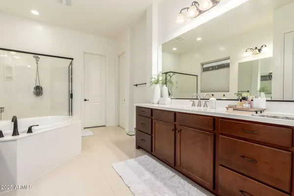 a bathroom with a double vanity sink mirror double and bathtub