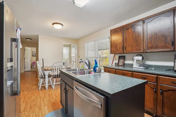 a kitchen that has a lot of cabinets in it and wooden floors