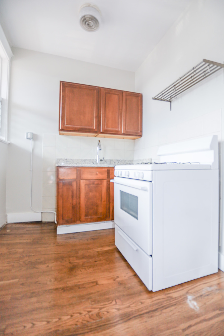 2659 North Spaulding Avenue, Unit 124 Chicago, IL 60647 - Photo 4 of 7 a view of a kitchen with wooden floor and electronic appliances