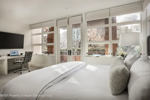 a bedroom with a large bed and a flat tv screen on the dresser