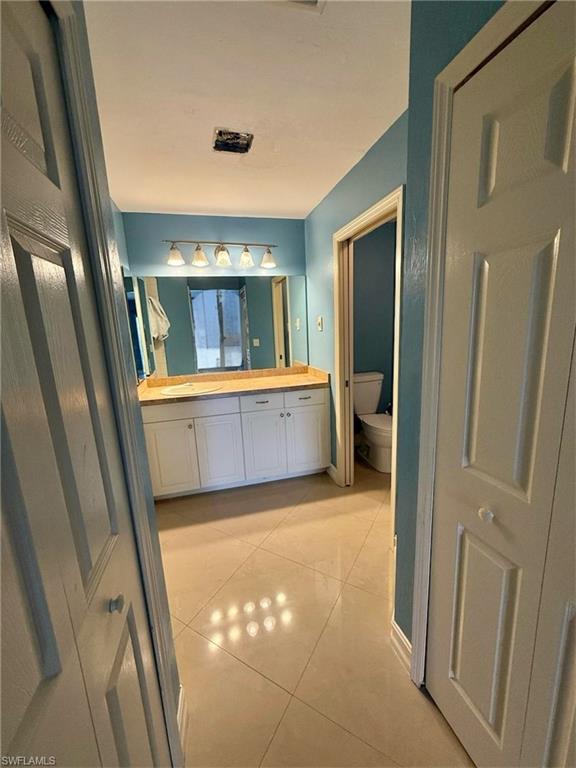 3908 Lee Boulevard Lehigh Acres, FL 33971 - Photo 8 of 24 Bathroom with vanity, toilet, and tile patterned flooring