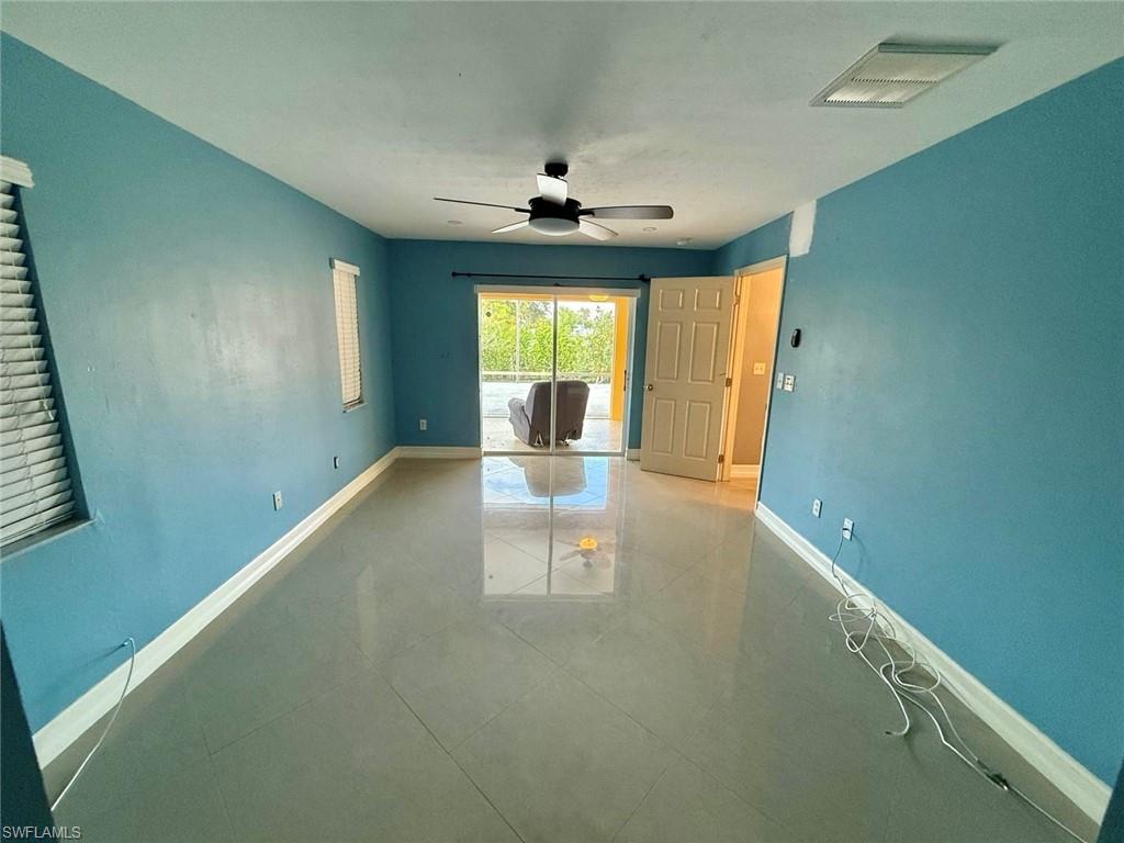 3908 Lee Boulevard Lehigh Acres, FL 33971 - Photo 9 of 24 Tiled empty room with ceiling fan