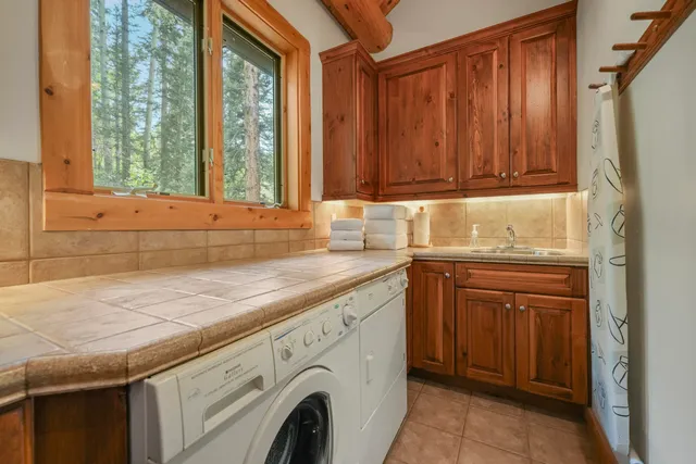 a utility room with granite countertop cabinets washer and dryer