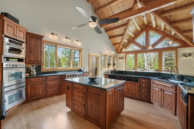 a kitchen with stainless steel appliances granite countertop a stove a sink and dishwasher a oven with wooden cabinets