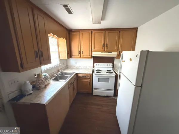 a kitchen with a sink a refrigerator a stove a washer dryer and cabinets
