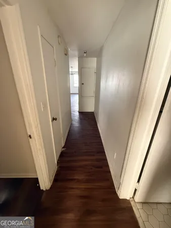 a view of a hallway with wooden floor and staircase