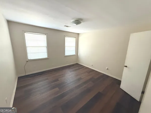 an empty room with wooden floor and window