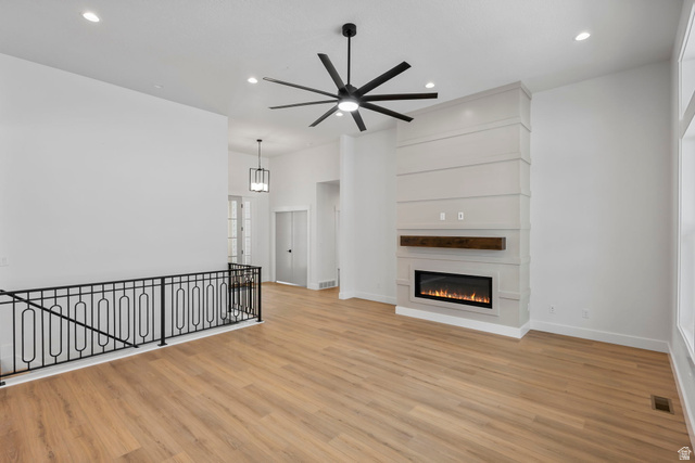710 East Mountain Road North Ogden, UT 84414 - Photo 24 of 36 Unfurnished living room featuring a glass covered fireplace, a ceiling fan, light wood-style flooring, and recessed lighting