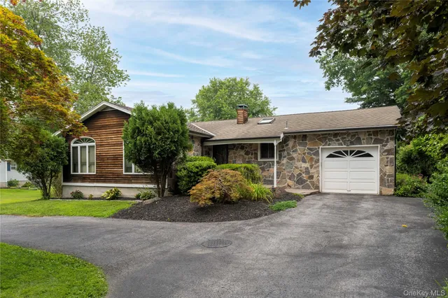 a front view of a house with a garden and trees