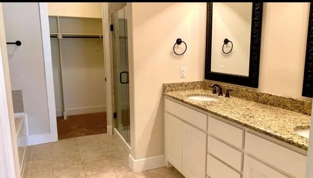 a bathroom with a granite countertop sink mirror and shower