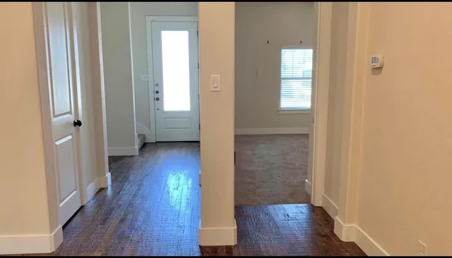 a view of a hallway with wooden floor