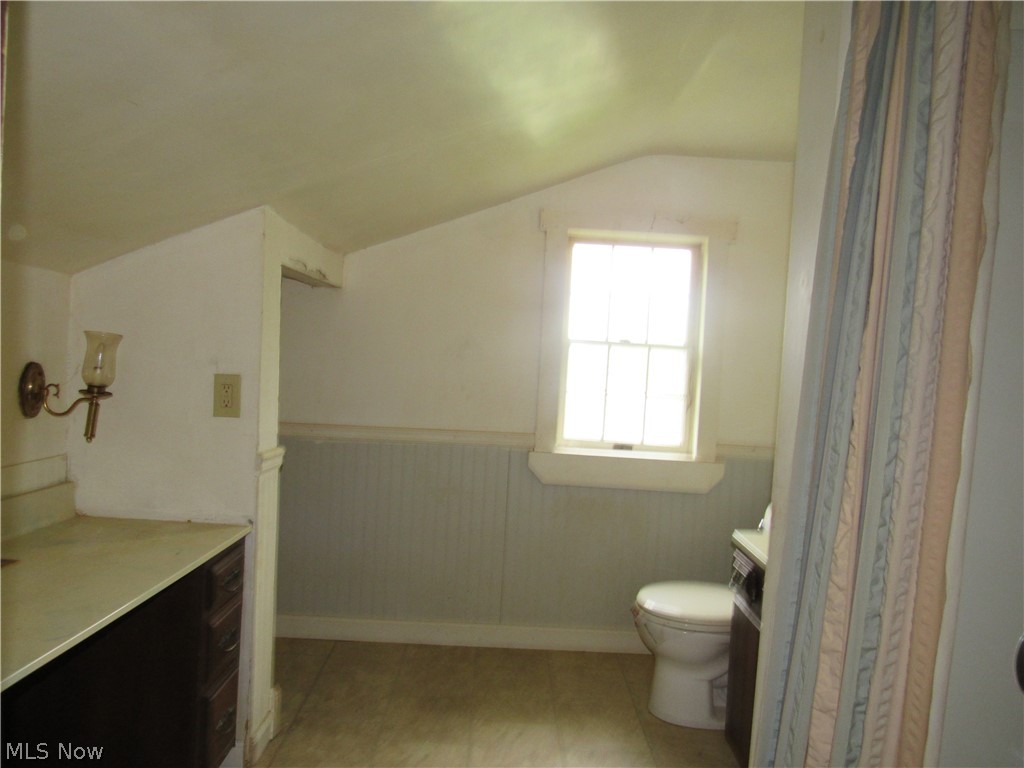 3462 Niles Carver Road Mineral Ridge, OH 44440 - Photo 27 of 33 Bathroom featuring vanity, toilet, tile floors, and lofted ceiling