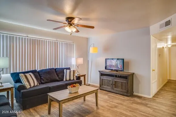 a living room with furniture and a wooden floor