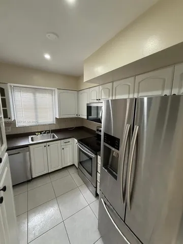 a kitchen with stainless steel appliances granite countertop a refrigerator stove and microwave