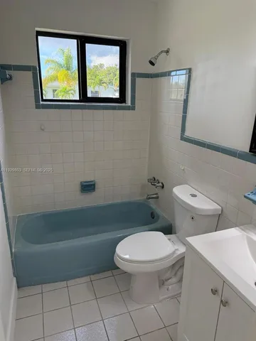 an empty room with a ceiling fan and a window