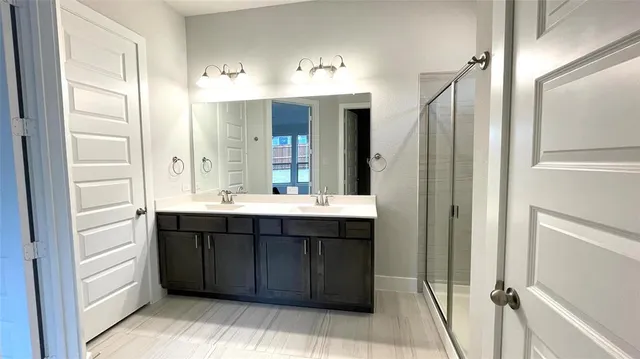 a bathroom with a shower sink and mirror