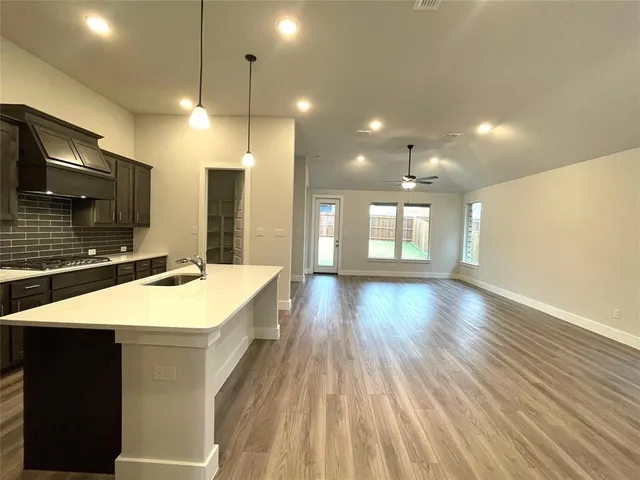 a kitchen with kitchen island a counter top space a sink and stainless steel appliances