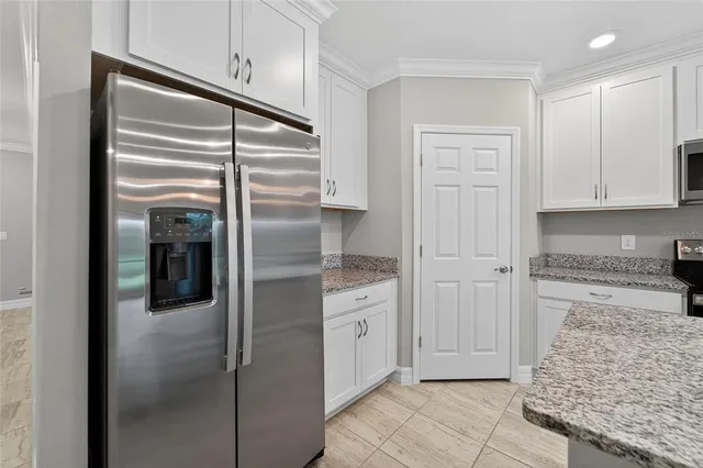 a kitchen with stainless steel appliances granite countertop a refrigerator and a stove