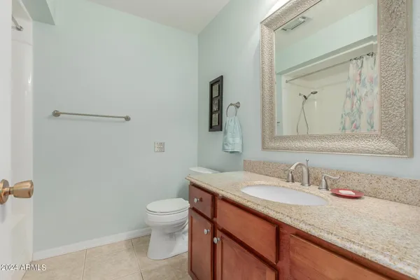 a bathroom with a granite countertop sink toilet and mirror