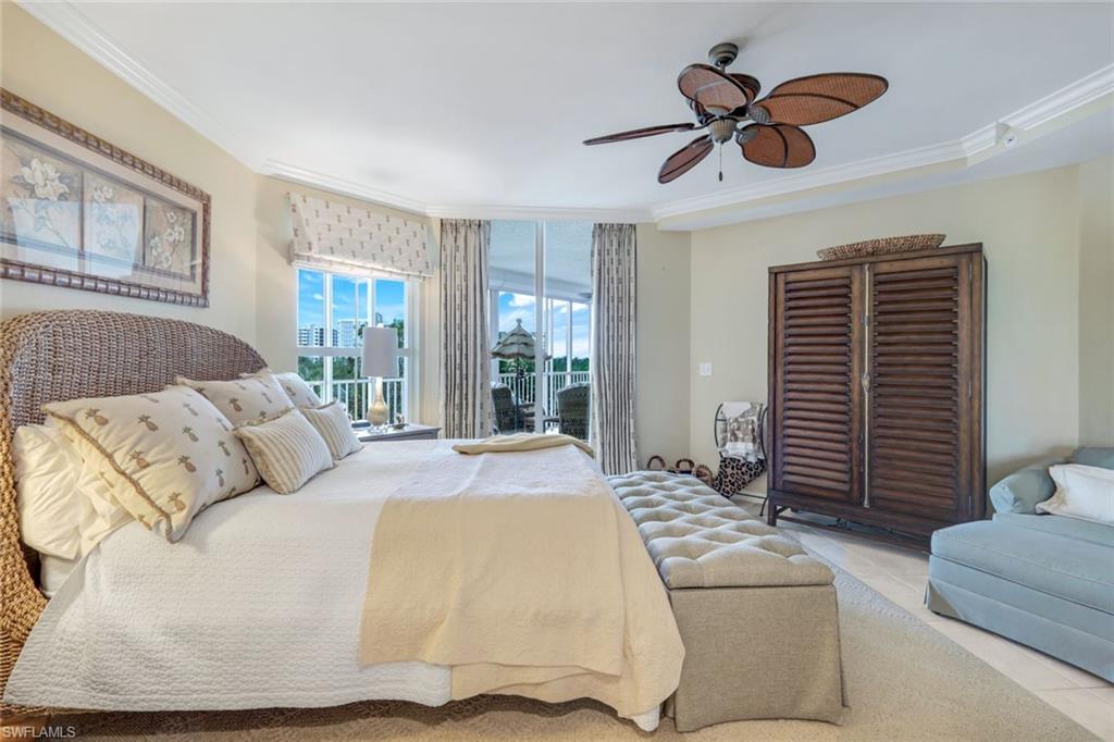 315 Dunes Boulevard, Unit 307 Naples, FL 34110 - Photo 18 of 44 a bedroom with a large bed chandelier and a window