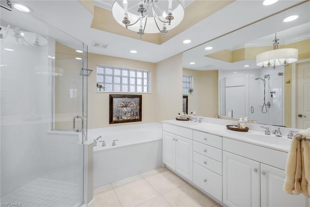 315 Dunes Boulevard, Unit 307 Naples, FL 34110 - Photo 19 of 44 a bathroom with a sink a large mirror and a shower