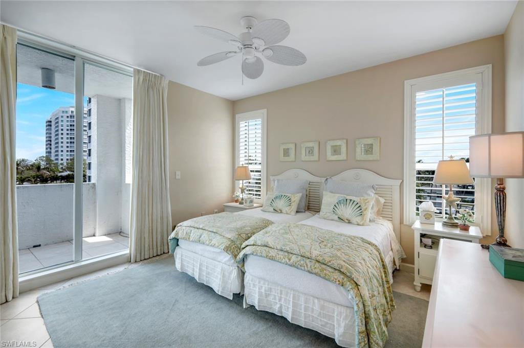 315 Dunes Boulevard, Unit 307 Naples, FL 34110 - Photo 21 of 44 a large bedroom with a bed and glass door