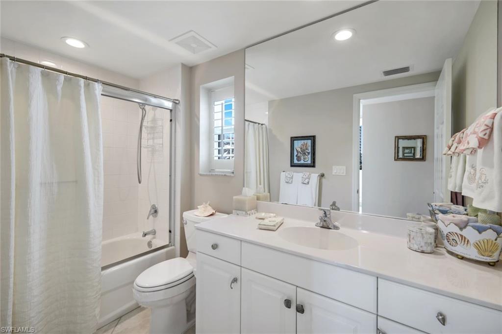 315 Dunes Boulevard, Unit 307 Naples, FL 34110 - Photo 22 of 44 a bathroom with double vanity sink a mirror and a toilet