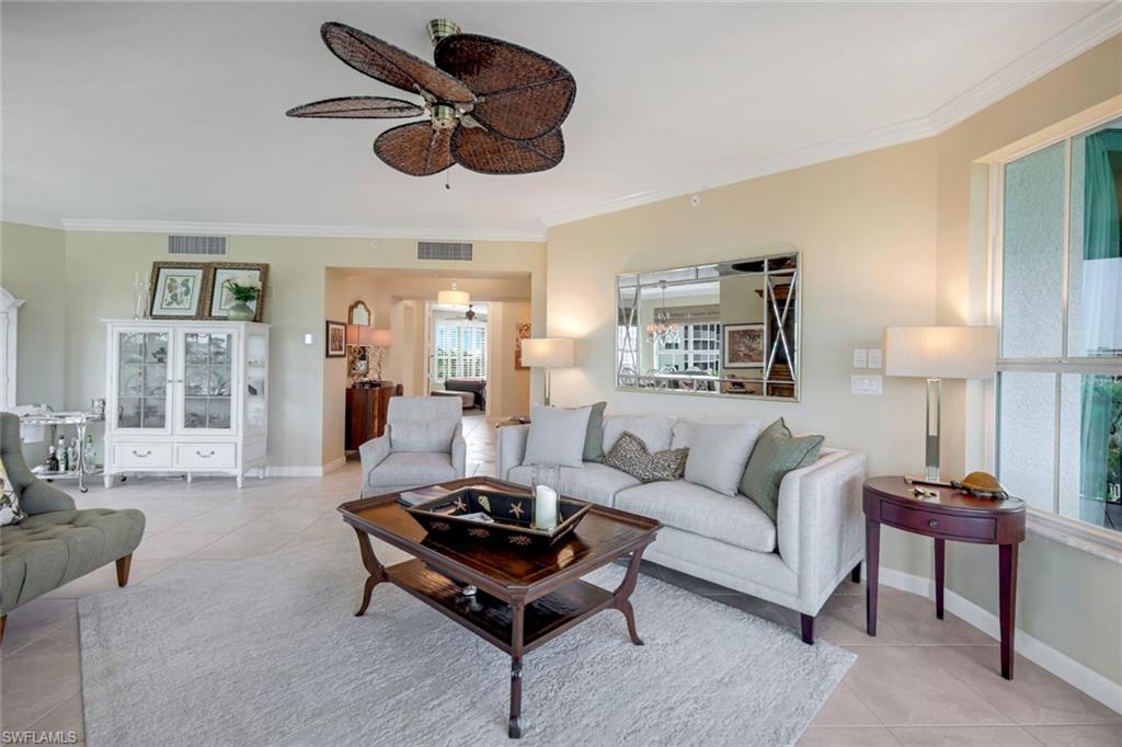 315 Dunes Boulevard, Unit 307 Naples, FL 34110 - Photo 6 of 44 a living room with furniture a rug and a chandelier