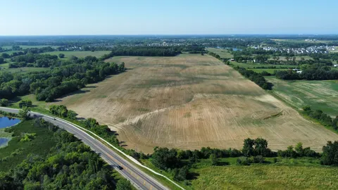 an aerial view of residential houses with outdoor space and trees