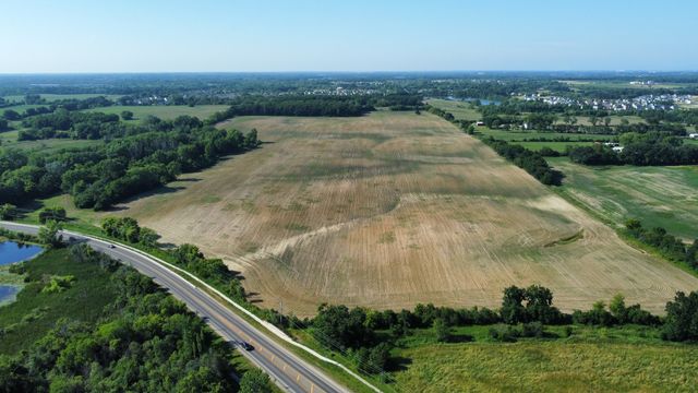 an aerial view of residential houses with outdoor space and trees