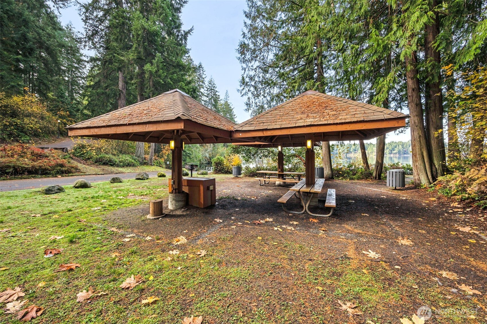 18410 Rampart Drive Southeast Yelm, WA 98597 - Photo 24 of 30 a view of a patio with a table and chairs under an umbrella with large trees