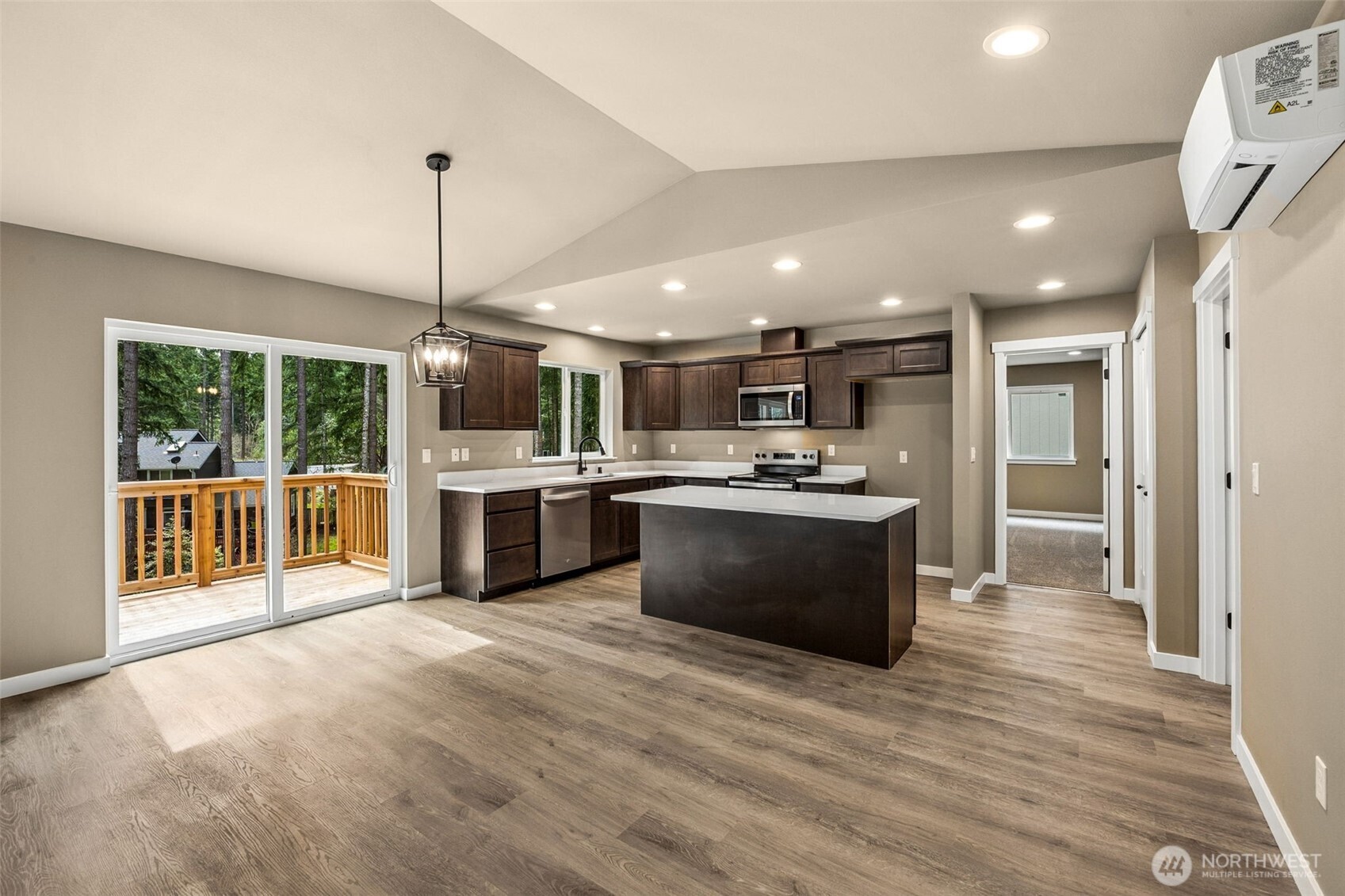 18410 Rampart Drive Southeast Yelm, WA 98597 - Photo 8 of 30 a large kitchen with stainless steel appliances kitchen island a large counter top a stove a sink cabinets and a wooden floor