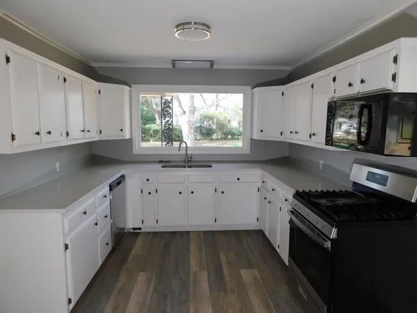 a kitchen with granite countertop a stove a sink dishwasher and a stove