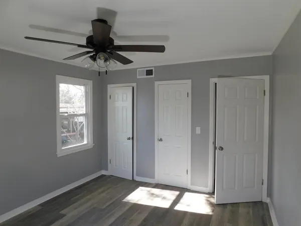 a view of an empty room and window chandelier fan