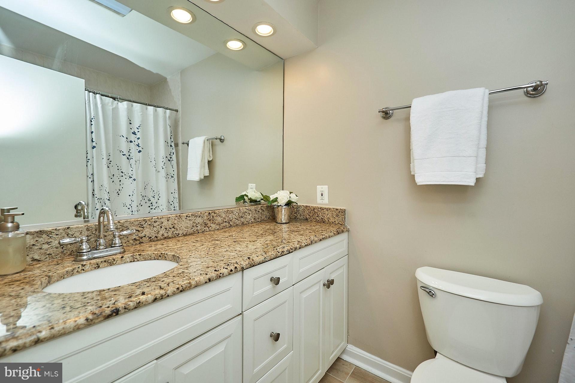 2421 Silver Fox Lane Reston, VA 20191 - Photo 22 of 27 a bathroom with a granite countertop sink a toilet and a mirror
