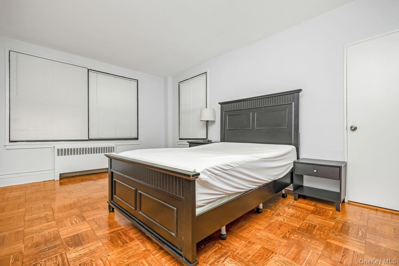 98-50 63rd Drive, Unit 1F Queens, NY 11374 - Photo 12 of 15 a spacious bedroom with a bed and a table in it