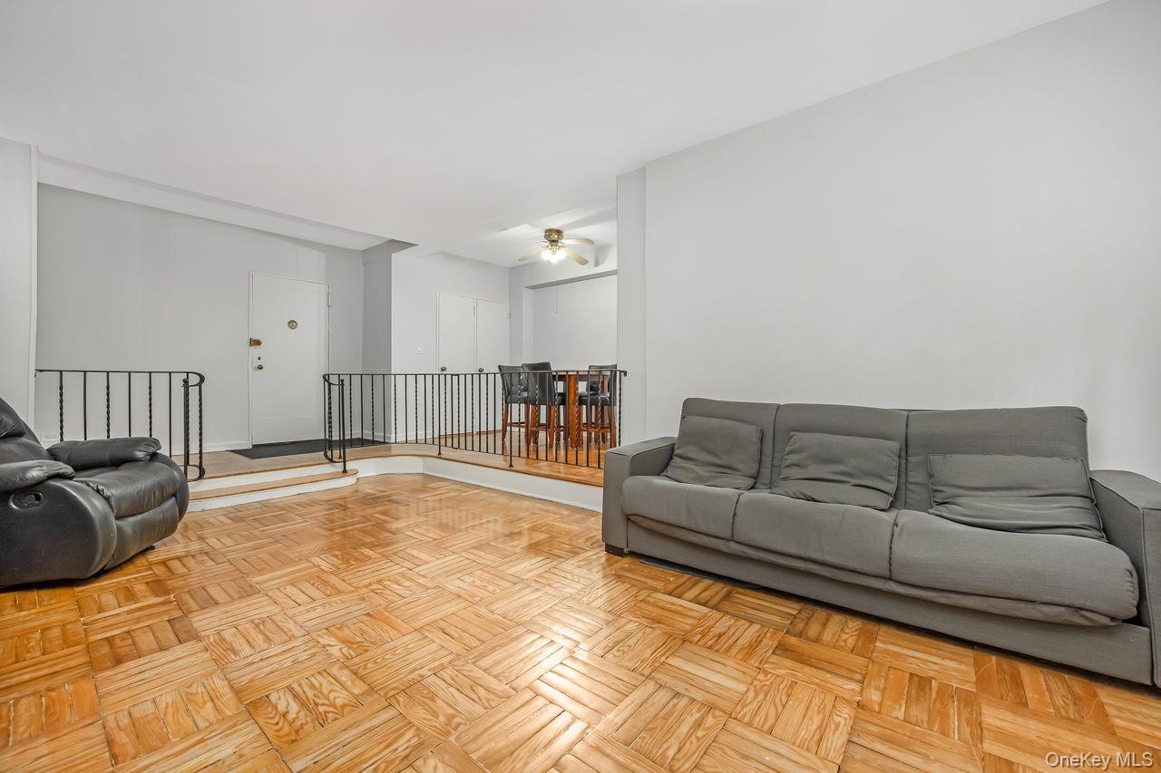 98-50 63rd Drive, Unit 1F Queens, NY 11374 - Photo 6 of 15 a living room with a couch and dresser