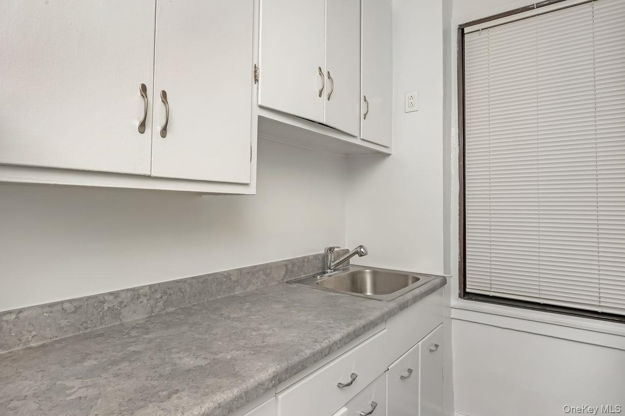 98-50 63rd Drive, Unit 1F Queens, NY 11374 - Photo 9 of 15 a kitchen with a sink and cabinets
